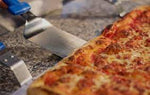 Stainless steel rectangular pizza server picking up a pizza slice - La Pizza Hub